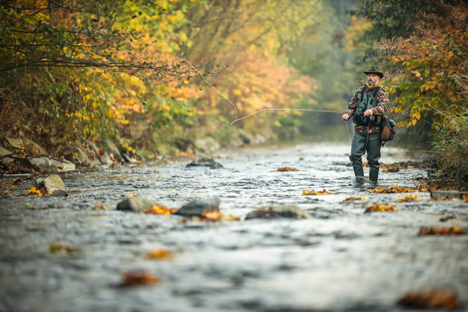 A North Carolina fly fishing guide standing in a river casting his fly.